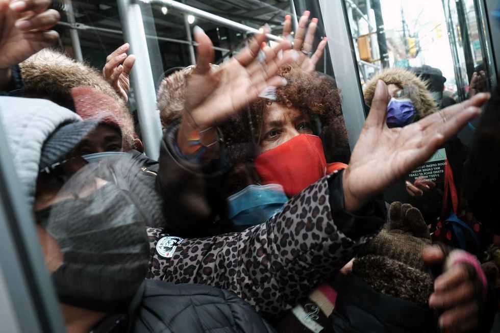 People form a large crowd as they attempt to receive COVID-19 testing kits from city workers distributing the kits along Flatbush Avenue in Brooklyn on Dec. 24, 2021