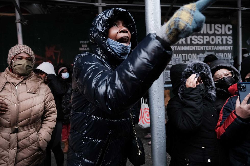 People form a large crowd as they attempt to receive COVID-19 testing kits from city workers distributing the kits along Flatbush Avenue in Brooklyn on Dec. 24, 2021