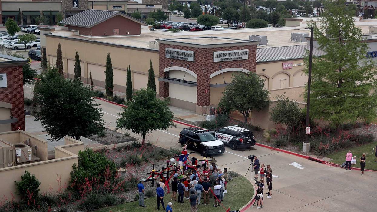 People gather around a memorial at one of the entrances to the Allen Premium Outlets mall on May 7, 2023, in Allen, Texas. According to reports, a shooter opened fire at the outlet mall, killing eight people. The gunman was then killed by an Allen Police officer that was responding to an unrelated call.