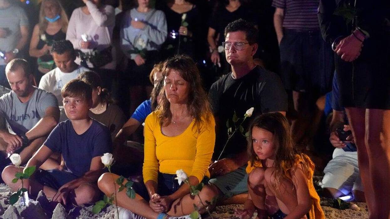 People gather at a vigil, late Monday, June 28, 2021, in Surfside, Fla. The vigil remembered those that died, are missing and those injured after a residential building collapsed last Thursday.