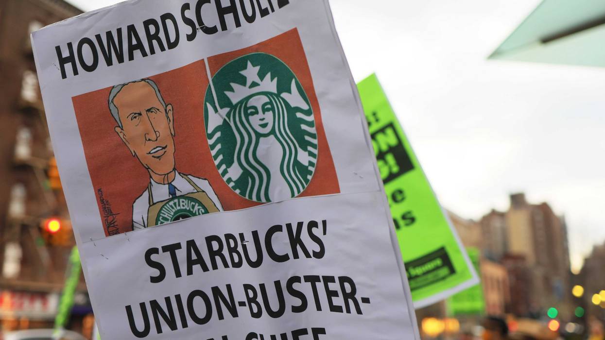 People hold signs while protesting in front of Starbucks on April 14, 2022 in New York City. Activists gathered to protest Starbucks' CEO Howard Schultz anti-unionization efforts and demand the reinstatement of workers fired for trying to unionize.