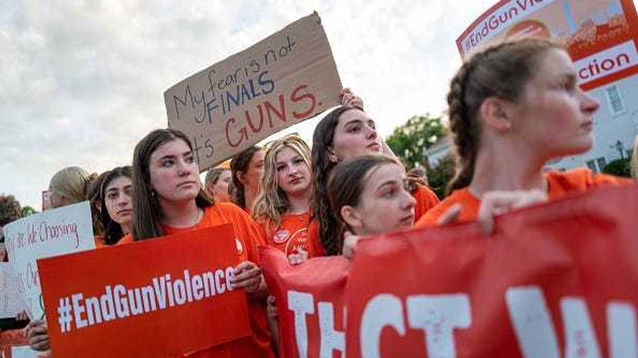 People hold up signs during a rally for National Gun Violence Awareness Day on June 03, 2022 in Newtown, Connecticut. Across the nation people are wearing orange and joining rallies as they demand change to America's gun laws.