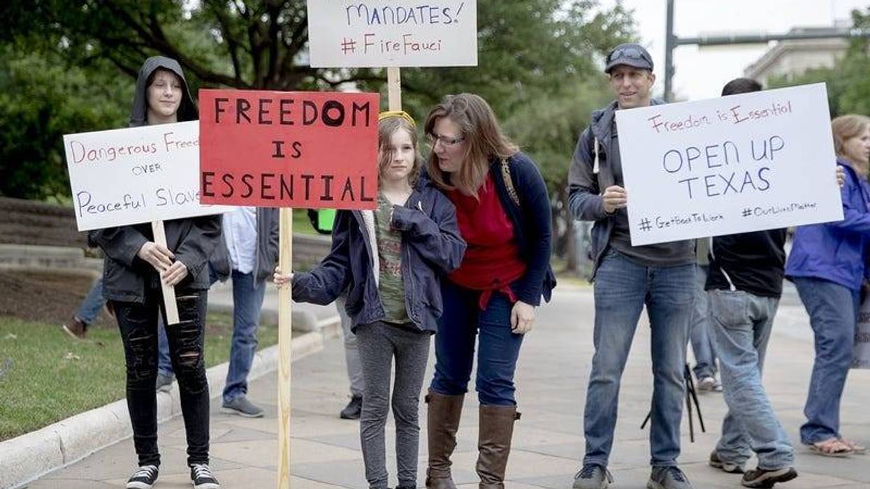 People hold up signs protesting government mandated shutdowns due to the coronavirus pandemic during a \"You Can't Close America Rally\" at the Texas capitol building on Saturday, April 18, 2020, in Austin, Texas.