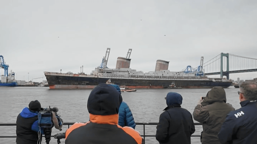 People hope to catch one last look at the SS United States as it sails down the Delaware River on its way out of Philadelphia.