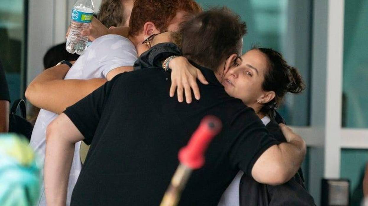 People hug outside the Surfside Community Center as they wait for news on June 25, 2021 in Surfside, Florida. The 12-story Champlain Towers South condo building partially collapsed on Thursday in Surfside, Florida