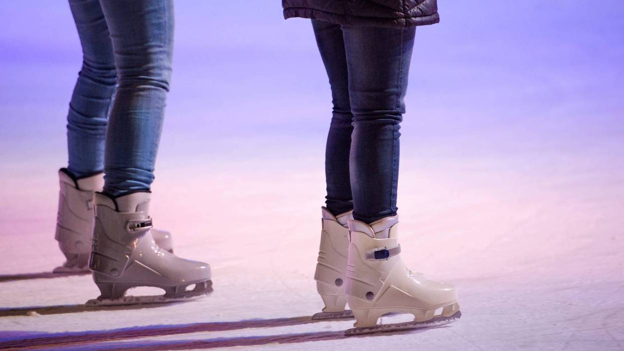People ice skating at night in historical centre