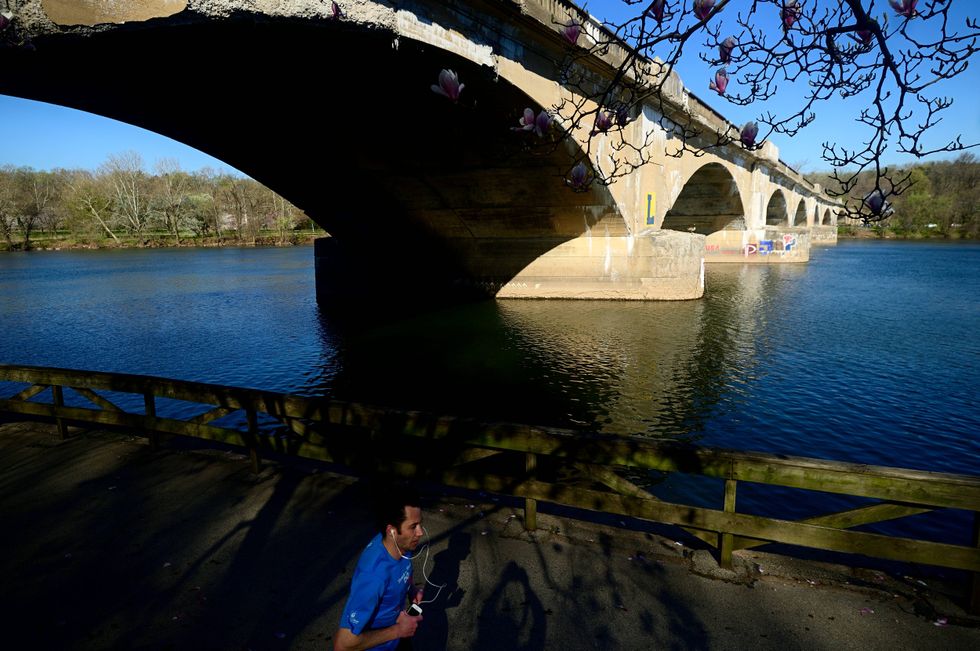 People jog, stroll and bike along the Schuylkill river in Philadelphia.