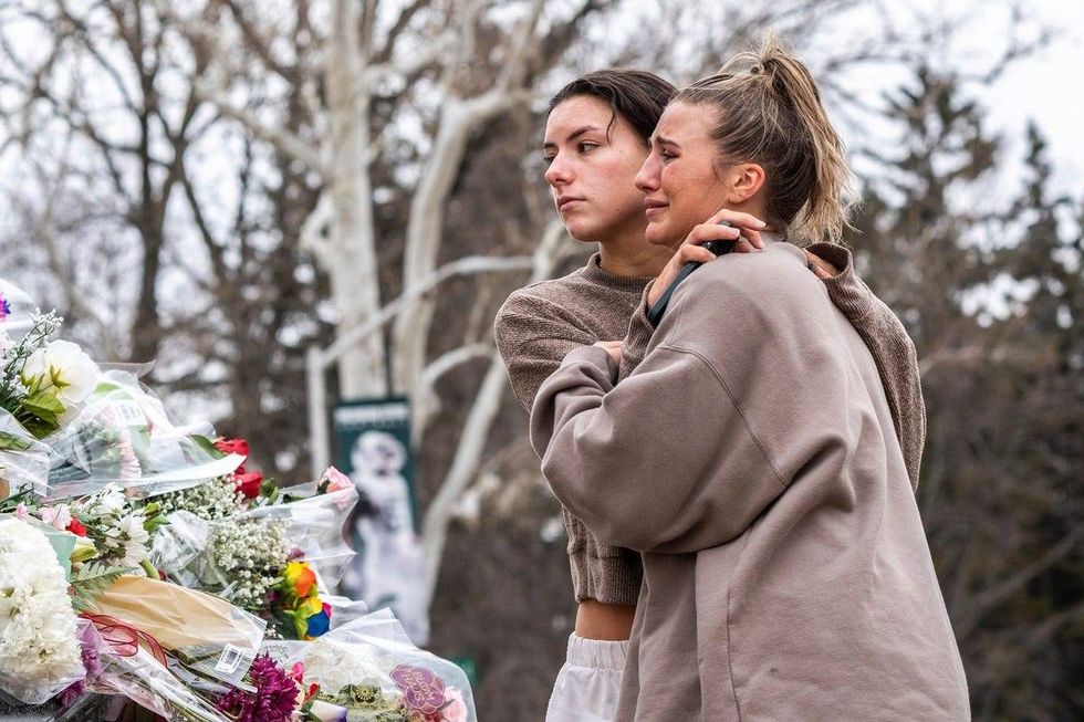 People leave flowers at the base of the Sparty statue following an active shooting incident on the Michigan State University campus in East Lansing on Tuesday, February 14, 2023, that left three people dead and multiple injured.