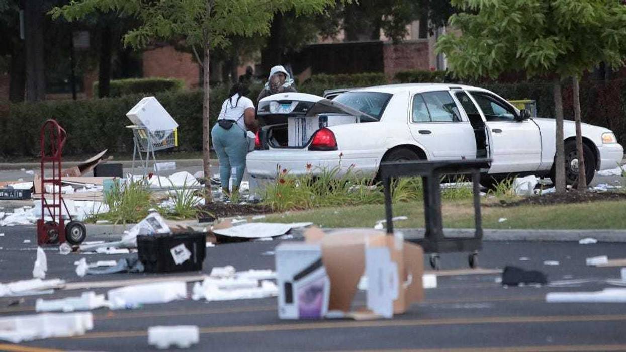 People load merchandise into a car near a looted Best Buy store after parts of the city had widespread looting and vandalism, on August 10, 2020 in Chicago, Illinois.