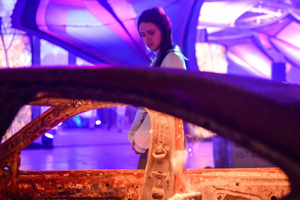 People look at destroyed cars at the