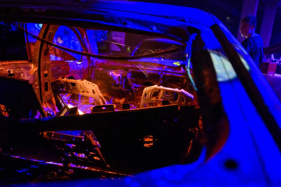 People look at destroyed cars at the