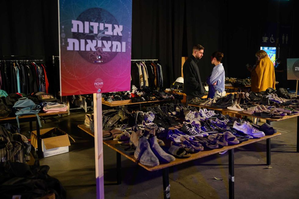 People look at "lost and found" tables with personal items collected from the Nova festival site at the