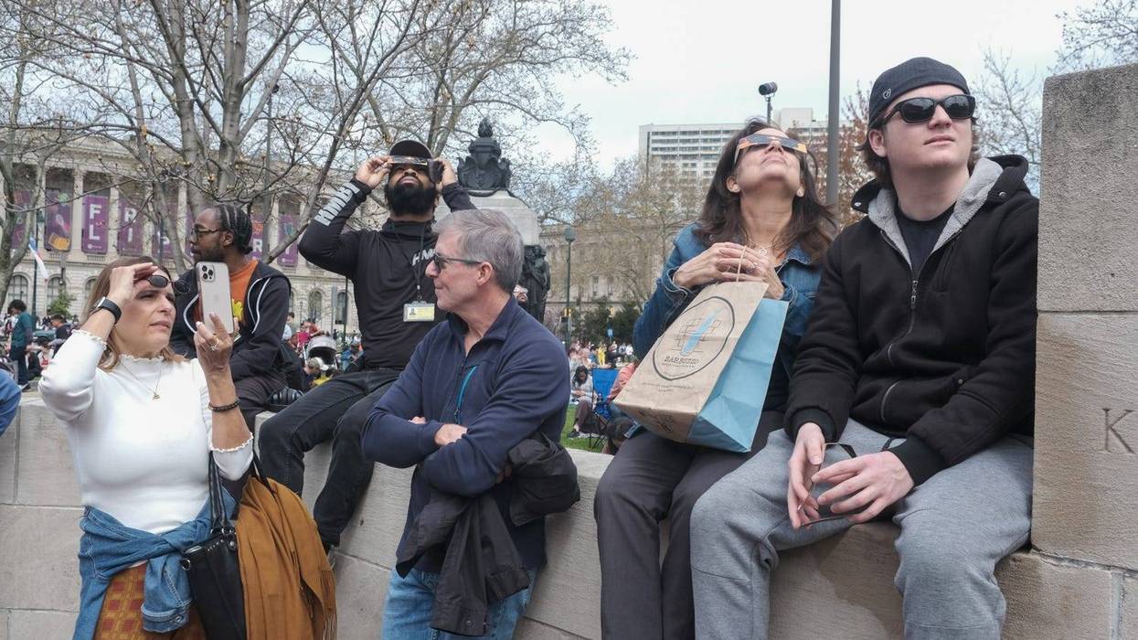 People look up at the Solar Eclipse over Philadelphia on April 8, 2024