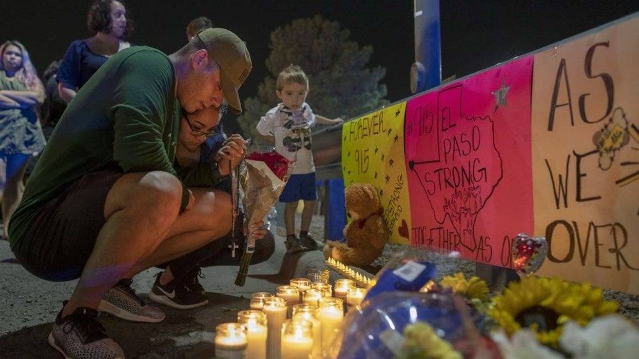 people mourn at a vigil after a shooting in an El Paso Walmart