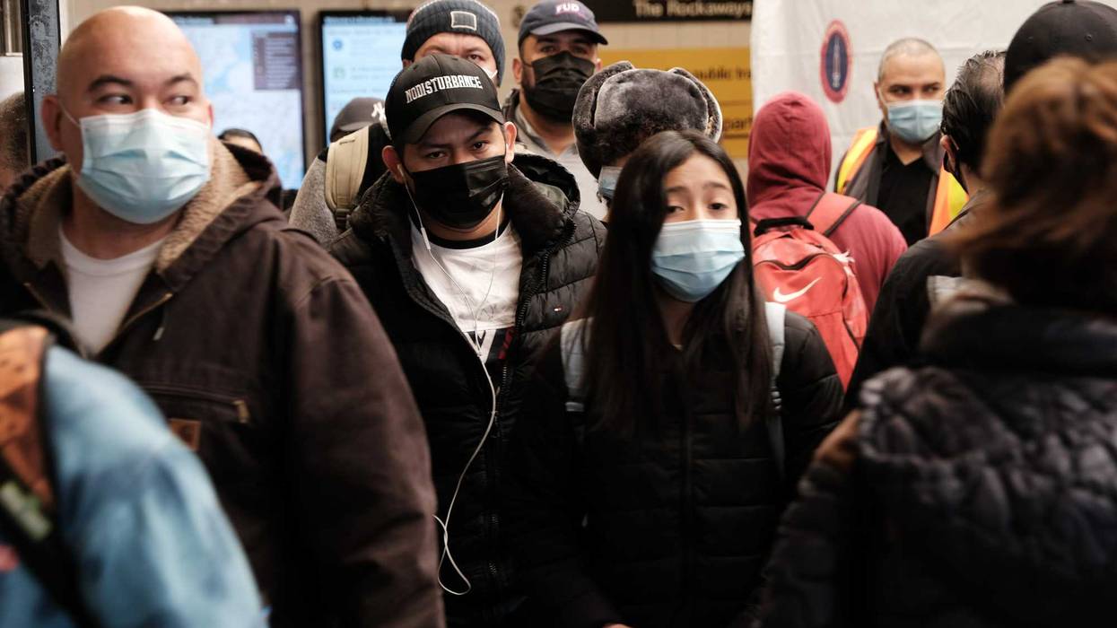 People move through the Broadway Junction subway station in Brooklyn as others wait in line to get a COVID-19 vaccination shot on May 12, 2021 in New York City