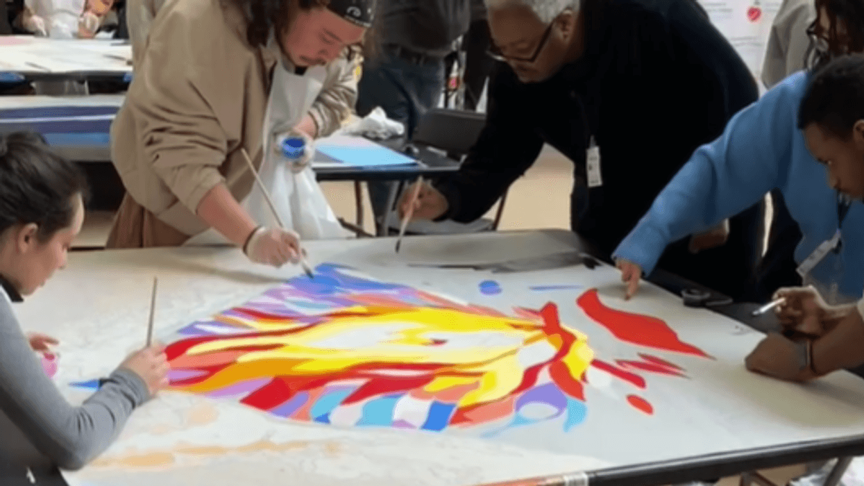 People of all ages painted sections of a mural dedicated to suicide prevention.