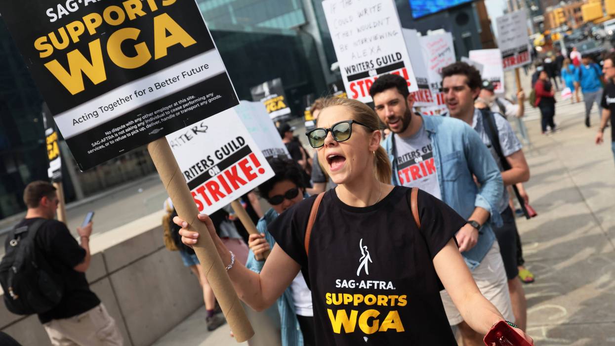 people on picket line with signs that say sag-aftra supports wga and writers guild on strike