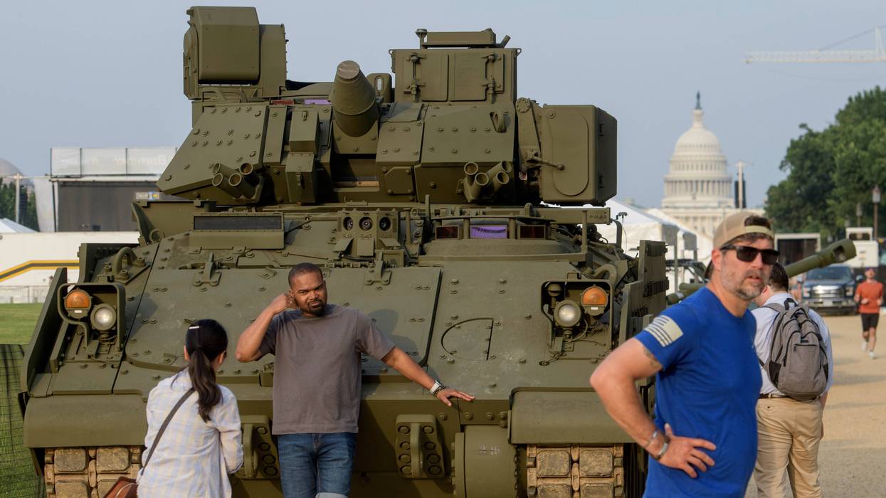 People pass by and take photos with a tank, parked on the National Mall, during preparations for an upcoming military parade commemorating the Army's 250th anniversary and coinciding with President Donald Trump's 79th birthday, Thursday, June 12, 2025, in Washington.