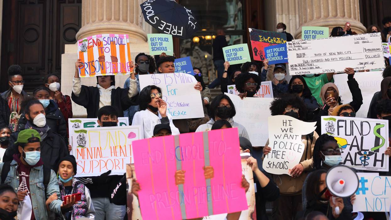 People pause at Tweed Courthouse as they march for police-free school on April 20, 2022 in New York City. Members of the Urban Youth Collaborative, parents, activist and community members gathered for a rally and march calling on City Council to divest from school police and invest in students.