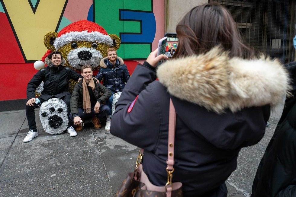 People pose for a photo at a sculpture of giant teddy bear with a Christmas hat on December 25, 2020 in New York City. People are celebrating Christmas during the pandemic as the city reports an increase of nearly 2,900 new cases and a 7 day positivity rate of 6.29%.
