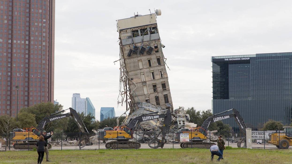 People pose in front of the "Leaning Tower of Dallas" in Dallas, Texas, the United States, Feb. 22, 2020