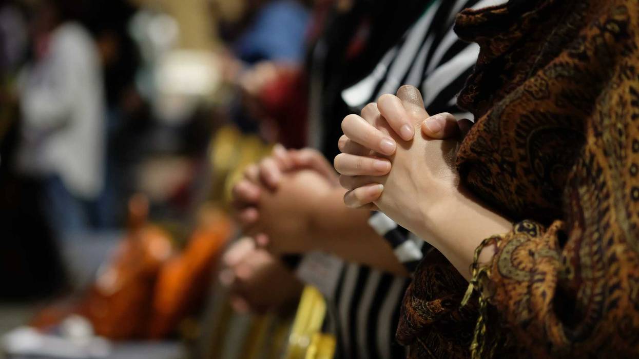 People praying, focus on hands.