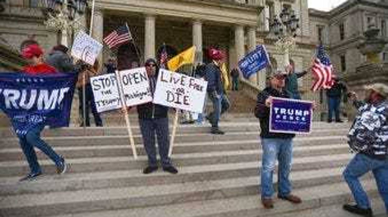 People protest against Michigan Gov. Gretchen Whitmer's stay-at-home order due to the coronavirus outbreak Wednesday, April 15, 2020, in downtown Lansing, Mich. at the State Capitol. (Matthew Dae Smith/ Lansing State Journal via AP)