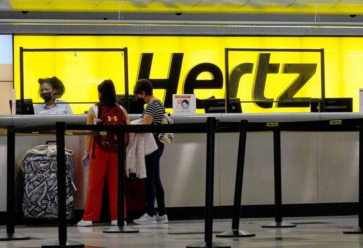 People rent cars at a Hertz car rental counter in the Miami International Airport on October 25, 2021 in Miami, Florida.