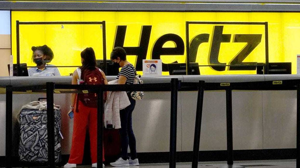 People rent cars at a Hertz car rental counter in the Miami International Airport on October 25, 2021 in Miami, Florida.