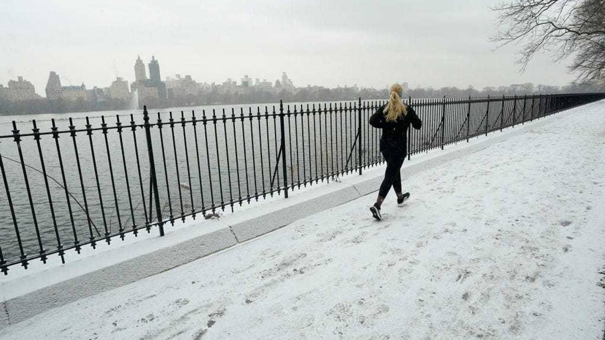 People run around Jacqueline Kennedy Onassis Reservoir in the snow in Central Park Jan. 6, 2025 in New York City as a major winter storm hits the Mid-Atlantic region.