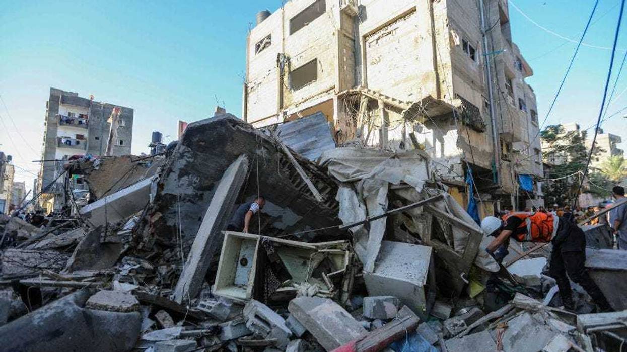 People search through buildings that were destroyed during Israeli air raids in the southern Gaza Strip on October 26, 2023 in Khan Yunis, Gaza.