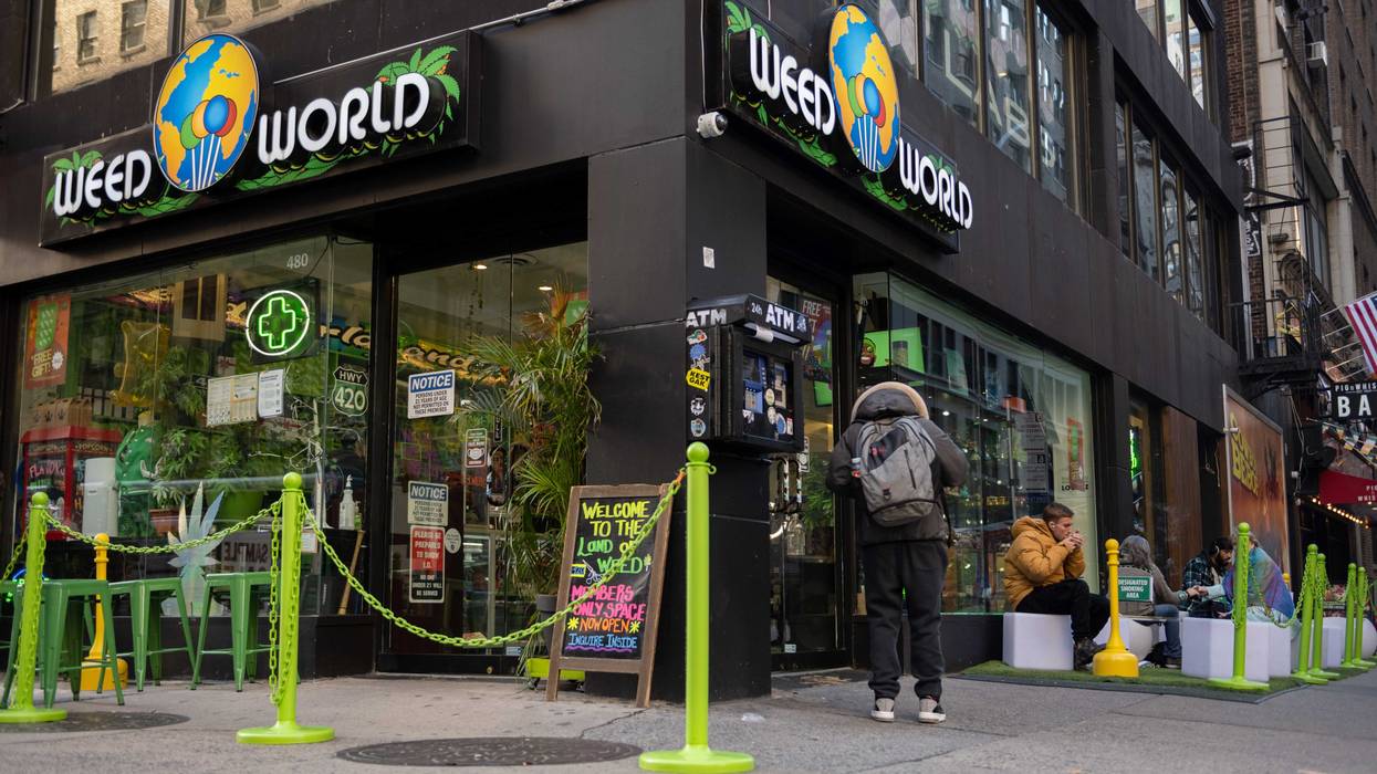 People sit in a "smoking section" outside Weed World on Nov. 16, 2021, in Midtown Manhattan