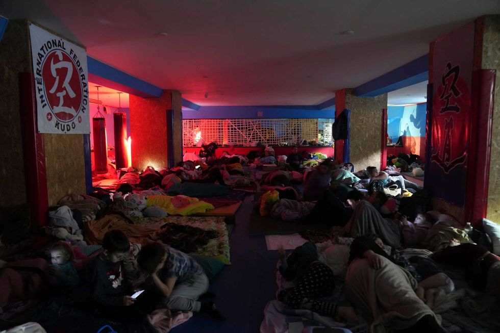People sleep on the floor in the improvised bomb shelter in a sports center, which can accommodate up to 2000 people, in Mariupol, Ukraine, late Sunday, Feb. 27, 2022