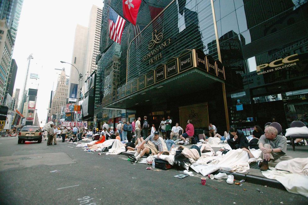 People sleep on the sidewalk outside the Renaissance Hotel during the blackout on Aug. 15, 2003