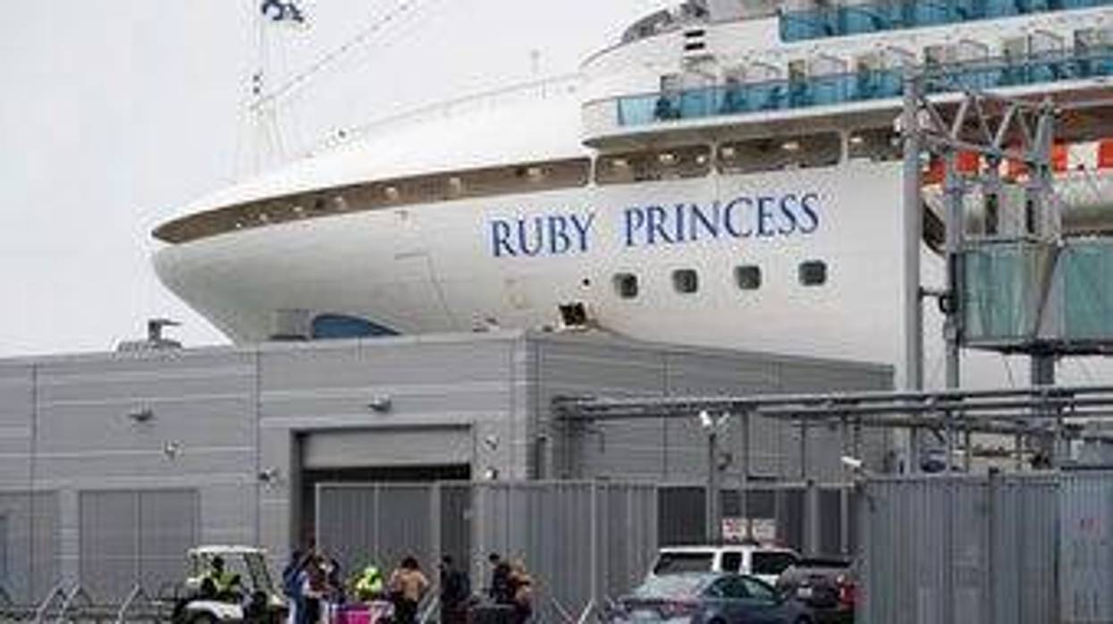 People stand on a pier outside the Ruby Princess cruise ship and wait to be picked up in San Francisco, Thursday, Jan. 6, 2021. The U.S. Centers for Disease Control and Prevention is investigating a cruise ship that docked in San Francisco on Thursday after a dozen vaccinated passengers tested positive for coronavirus.