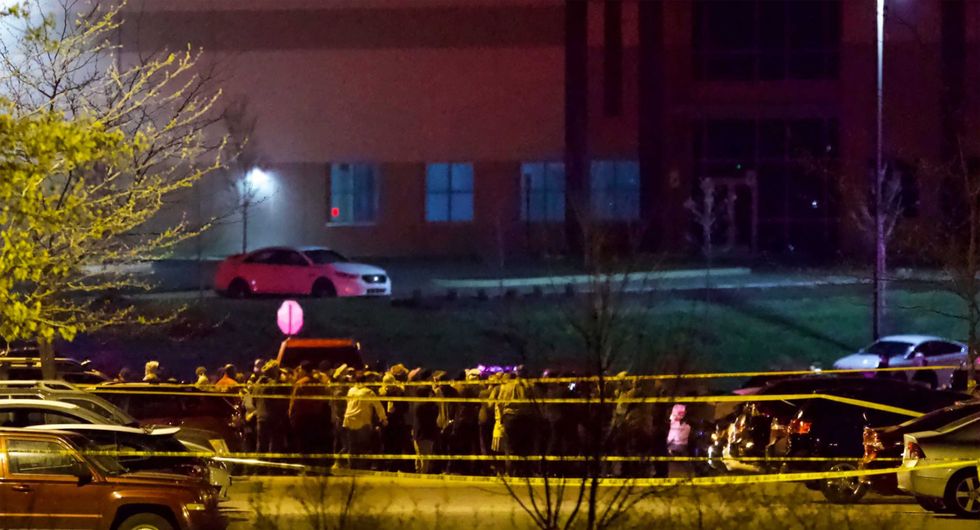 People stand outside a FedEx facility near Indianapolis International Airport after a shooting with multiple victims was reported late Thursday night, April 15, 2021