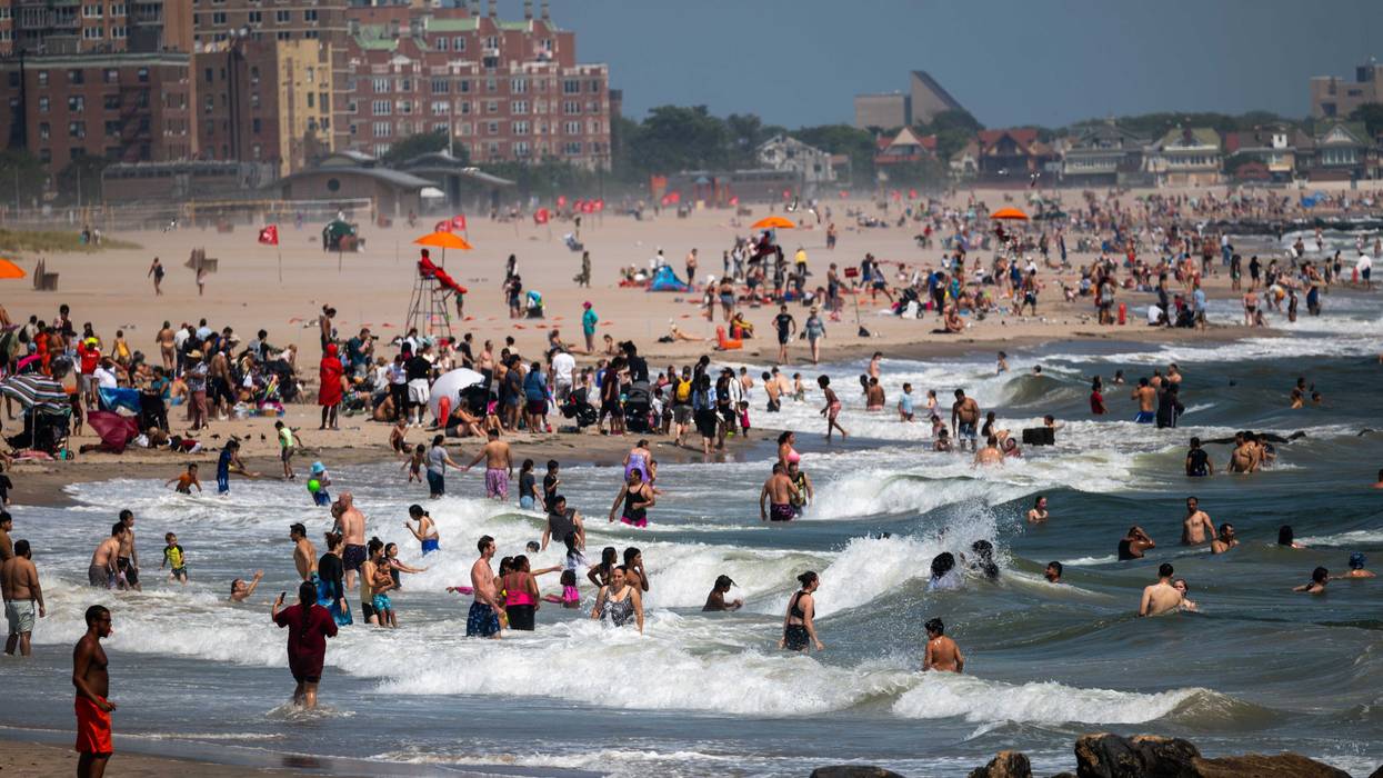 People swim in rough surf at Coney Island on July 30, 2024