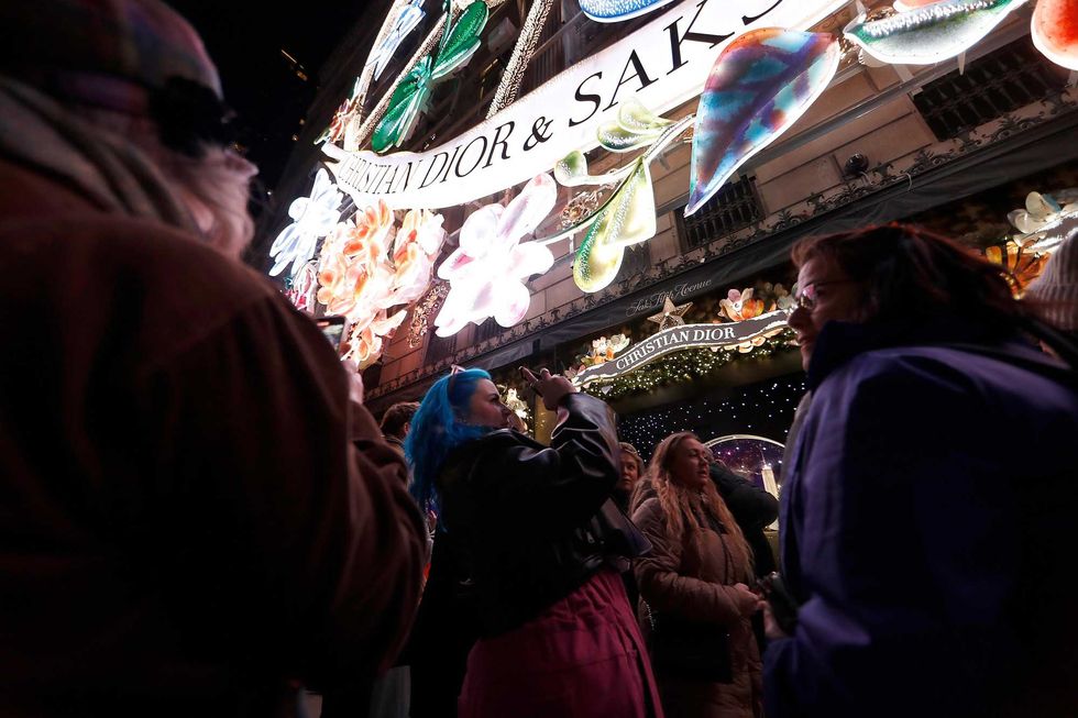 People take photos as Saks Fifth Avenue unveils its 2023 holiday windows on Nov. 20, 2023 in New York City.