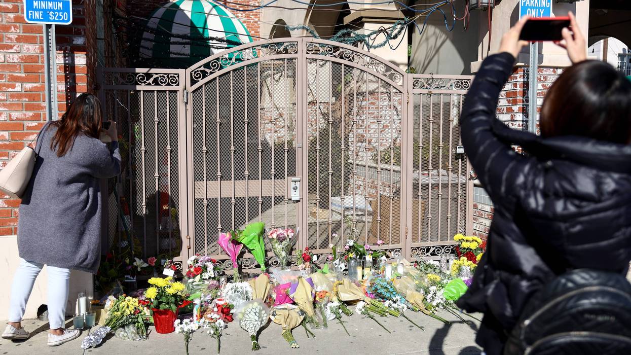 People take photos near a makeshift memorial outside the scene of a deadly mass shooting at a ballroom dance studio on January 23, 2023 in Monterey Park, California.