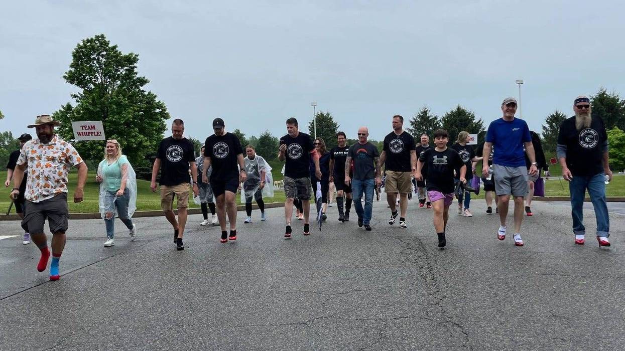 People taking part in the "Walk a Mile in Her Shoes" event in Collegeville, including men wearing heels.
