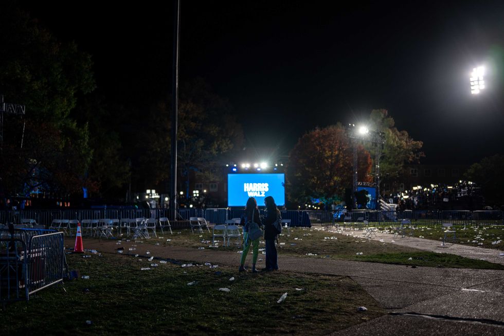 People talk with each other, amid the chairs and trash in an empty field after the election night watch party for Democratic presidential nominee, U.S. Vice President Kamala Harris at Howard University on November 06, 2024 in Wshington, DC. Americans cast their ballots today in the presidential race between Republican nominee former President Donald Trump and Vice President Kamala Harris, as well as multiple state elections that will determine the balance of power in Congress.