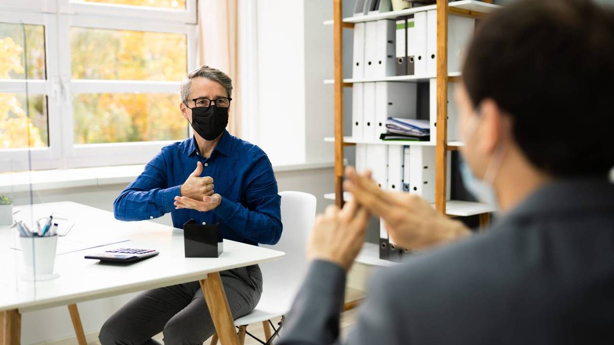People using sign language while wearing COVID-19 face masks.