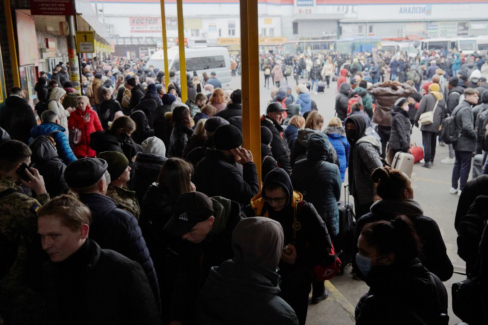 People wait for buses at a bus station as they attempt to evacuate the city on February 24, 2022 in Kyiv, Ukraine