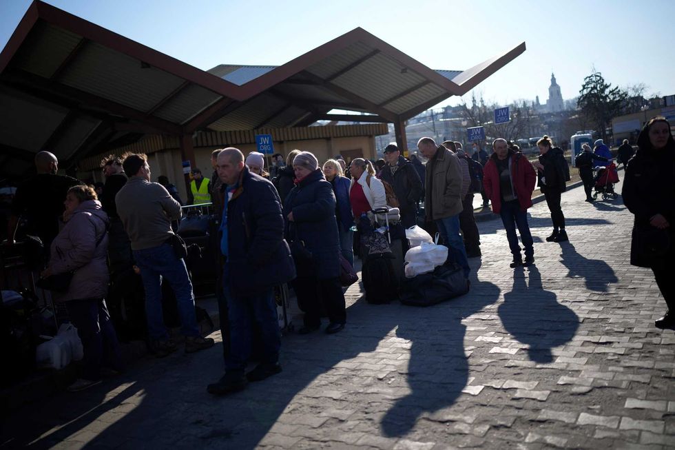 People wait in a line to board a train leaving for Lviv in Ukraine at the train station in Przemysl, Poland, Monday, March 14, 2022
