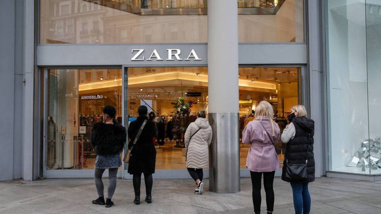 People wait outside a Zara store