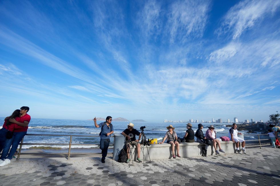 People wait to watch a total solar eclipse in Mazatlan, Mexico, Monday, April 8, 2024