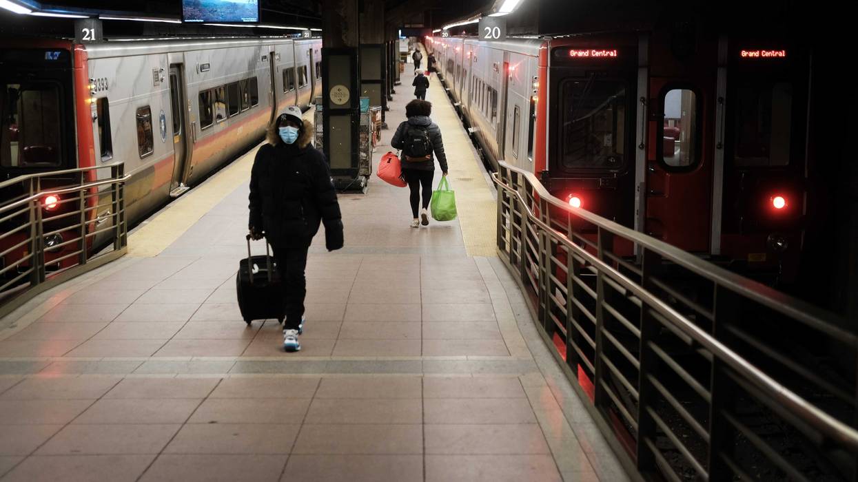 People walk along a train platform at Grand Central Terminal
