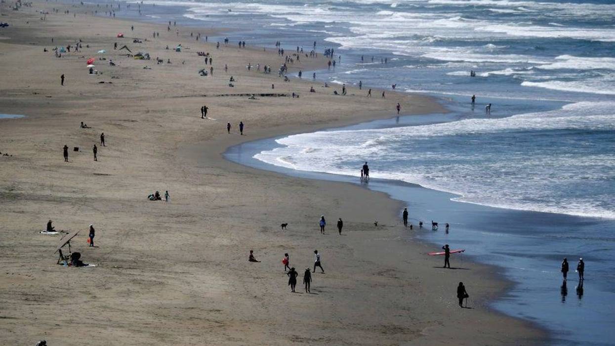 People walk along Ocean Beach on May 26, 2020 in San Francisco, California.