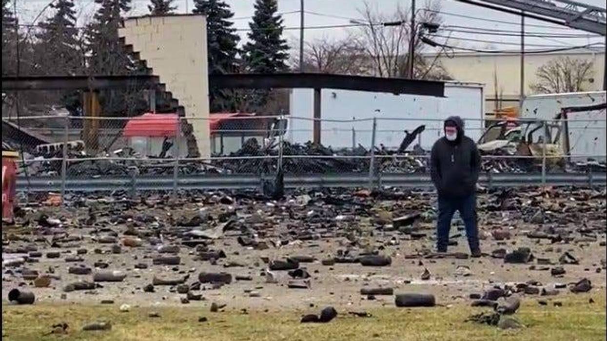 People walk around the site of Monday night's fire and explosions in Clinton Township.