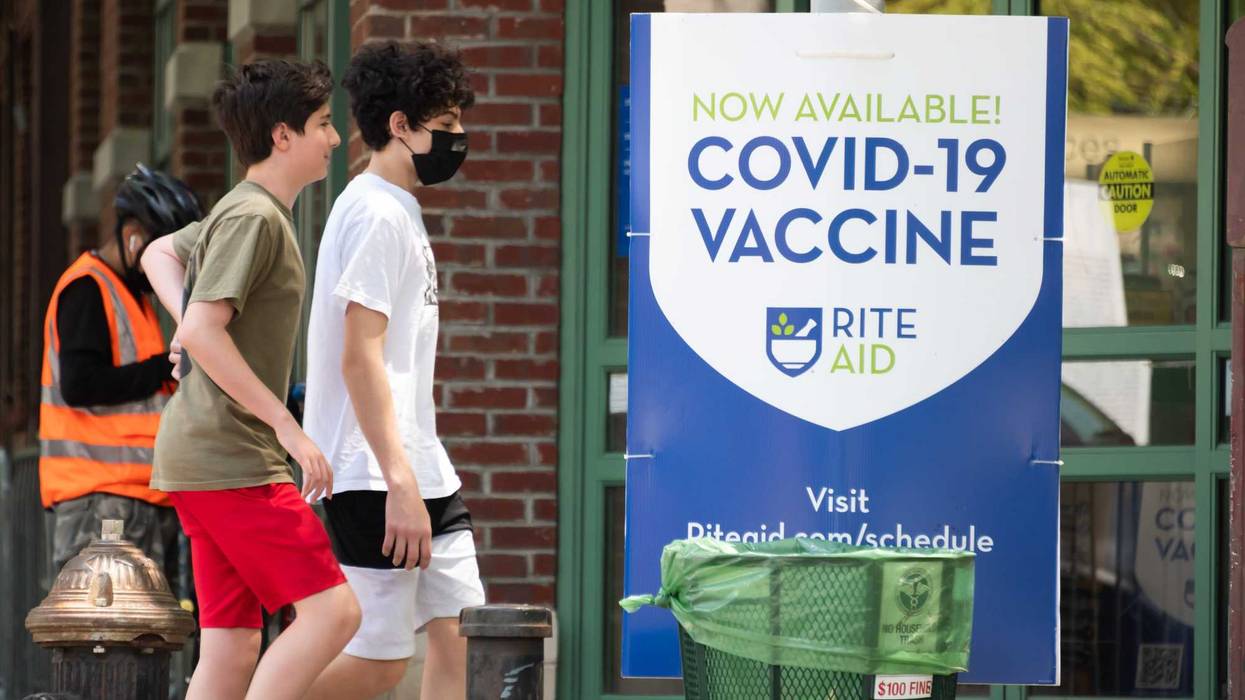 People walk by a sign that reads, "Now available! COVID-19 vaccine" in TriBeCa on May 27, 2021 in New York City. On May 19, all pandemic restrictions, including mask mandates, social distancing guidelines, venue capacities and restaurant curfews were lifted by New York Governor Andrew Cuomo.